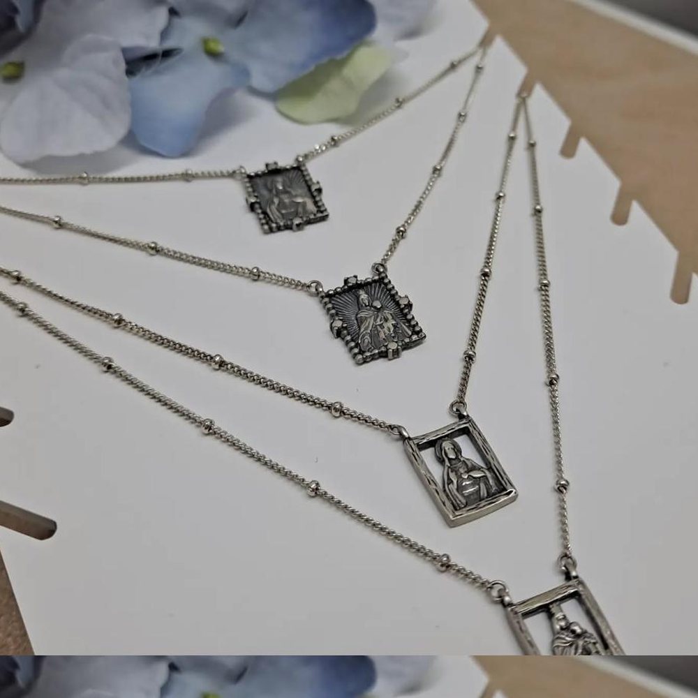Quatro fios em prata com medalhas religiosas rectangulares